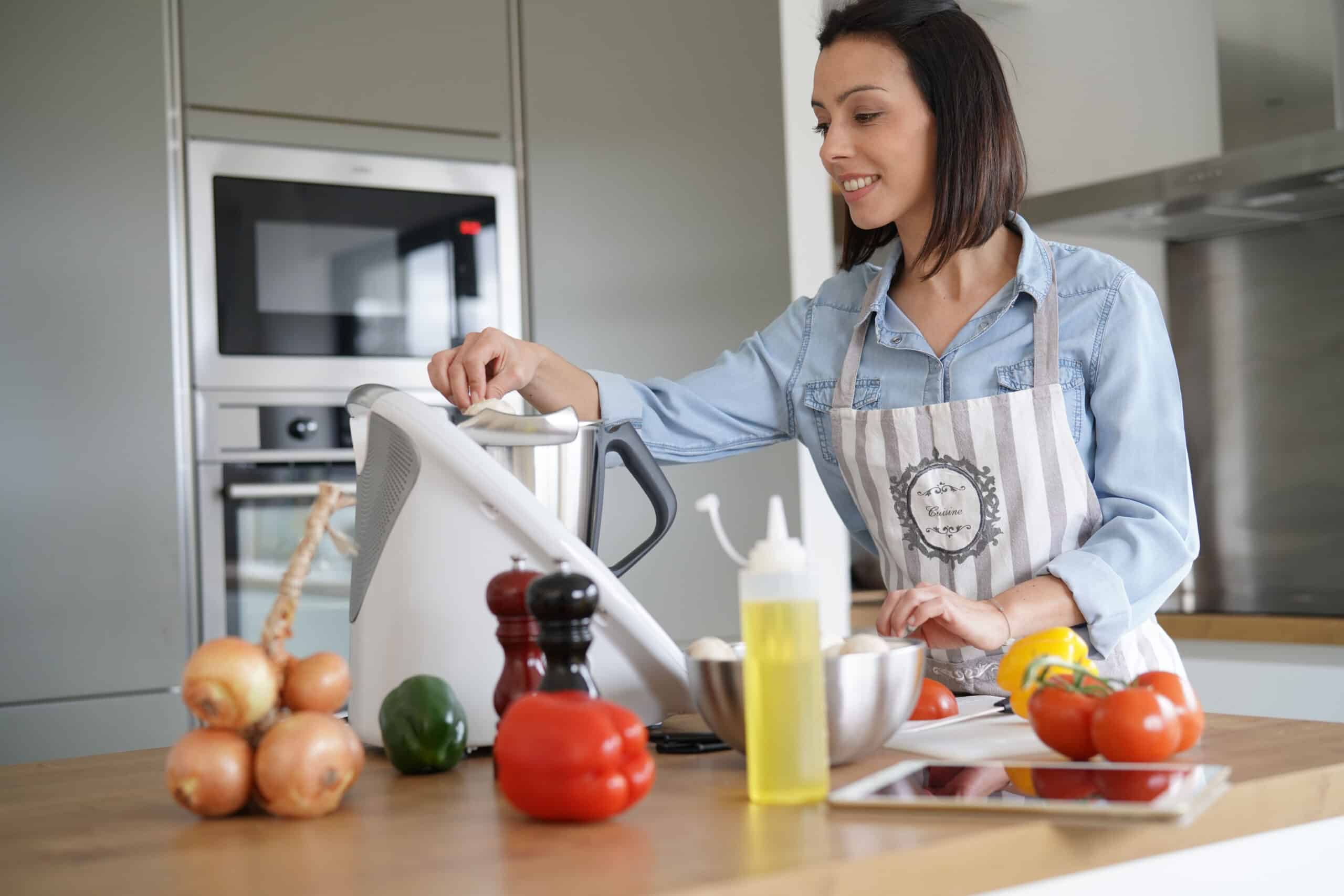 Une femme utilisant un robot cuiseur